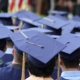Back view of several students at graduation wearing graduation caps