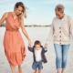 Front view of a grandmother, mother, and child having fun on a sandy beach