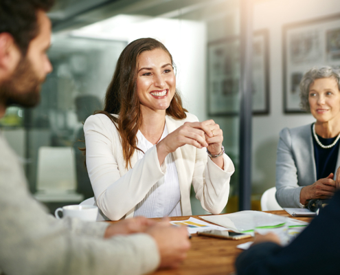 Front view of woman smiling while in meeting with investor