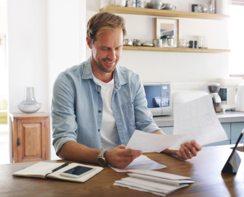 Happy, man and documents with tablet at house for financial planning