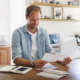 Happy, man and documents with tablet at house for financial planning