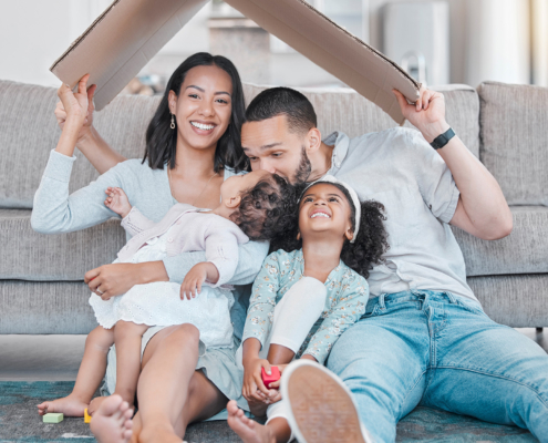 Happy family, cardboard roof or house life insurance in home living room