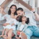 Happy family, cardboard roof or house life insurance in home living room